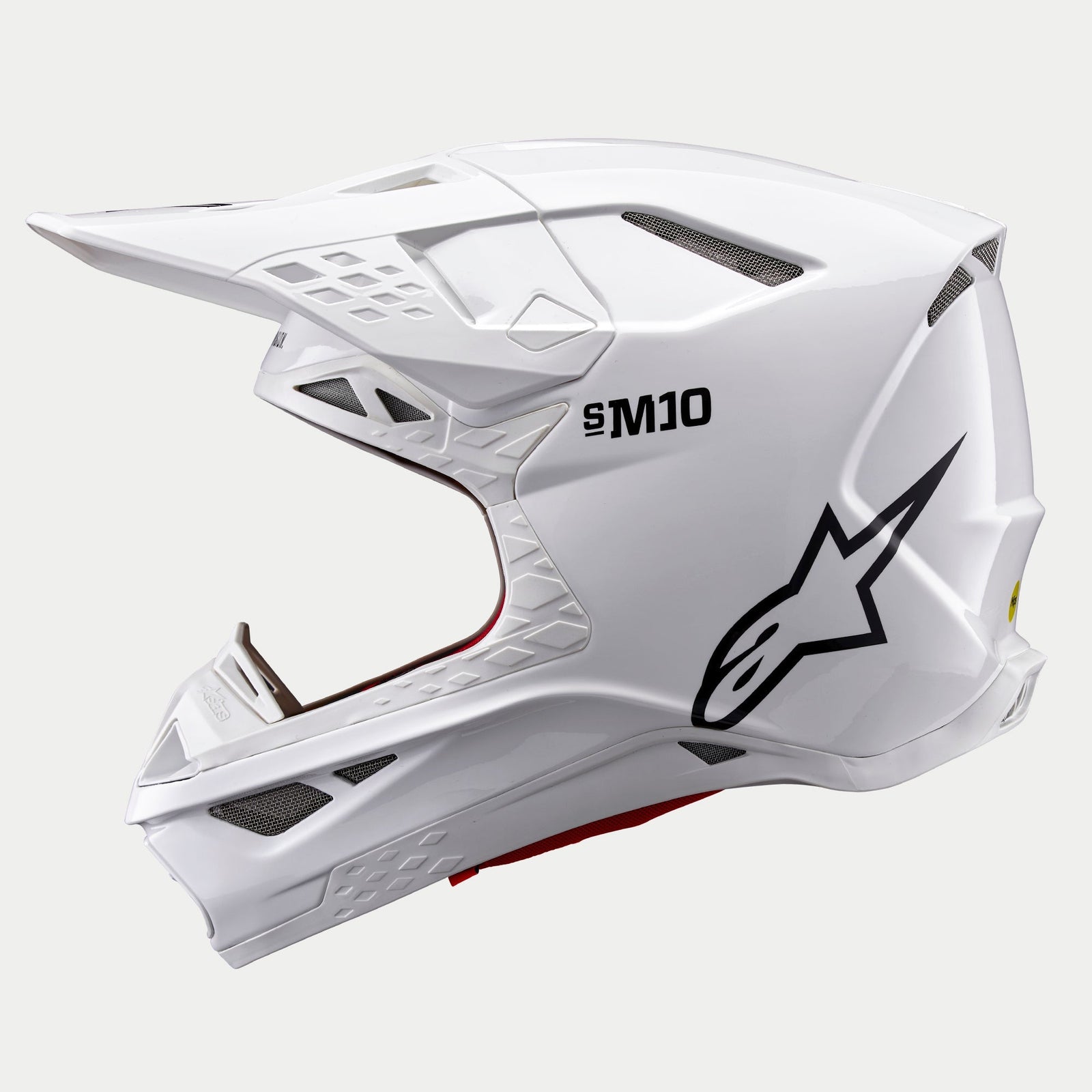 Capacete Alpinestars Supertech M10 Solid, capacete de motocross, branco brilhante, vista de perfil lateral com logótipo Astars preto e marca S-M10, com múltiplas aberturas de ventilação em malha e um design aerodinâmico elegante