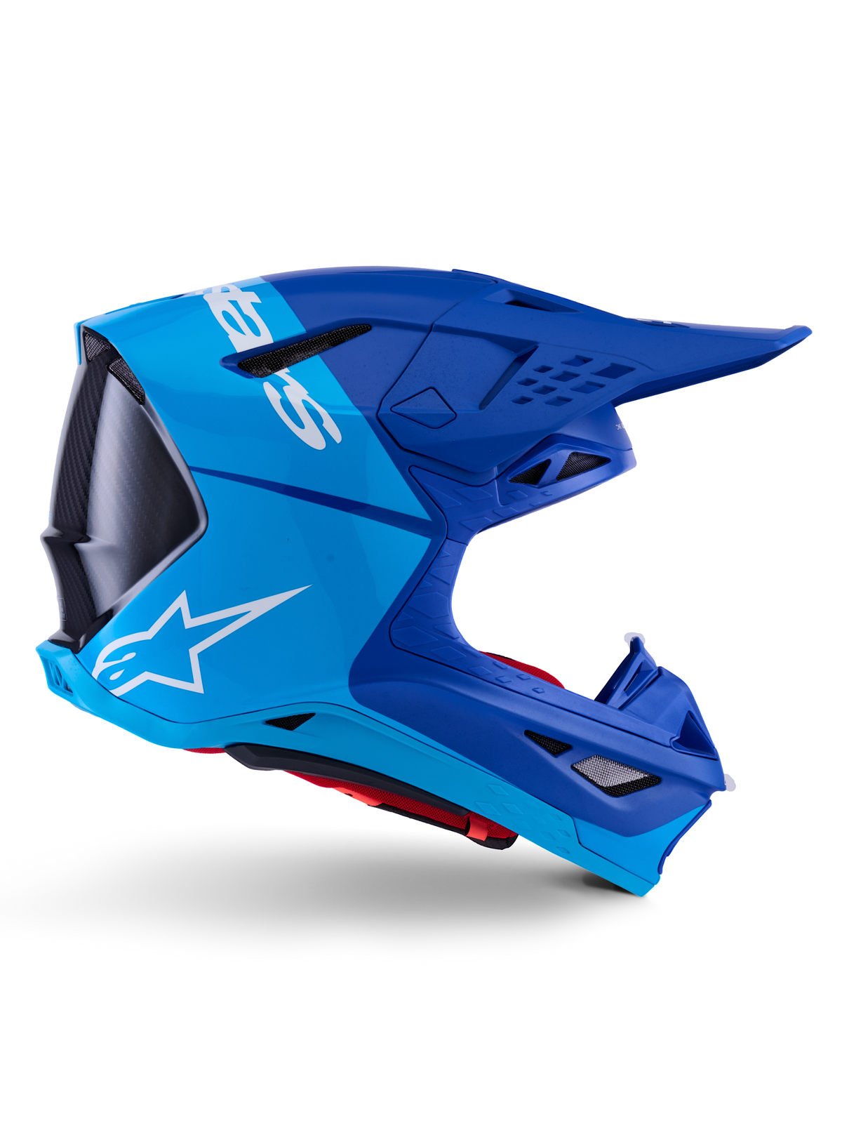 Capacete Alpinestars Supertech M10 Flood, capacete de motocross, azul metálico e azul médio com detalhes em carbono preto, vista de perfil lateral, com logótipo branco, design aerodinâmico com aberturas de ventilação, detalhes de textura em fibra de carbono, proteção profissional para competição off-road