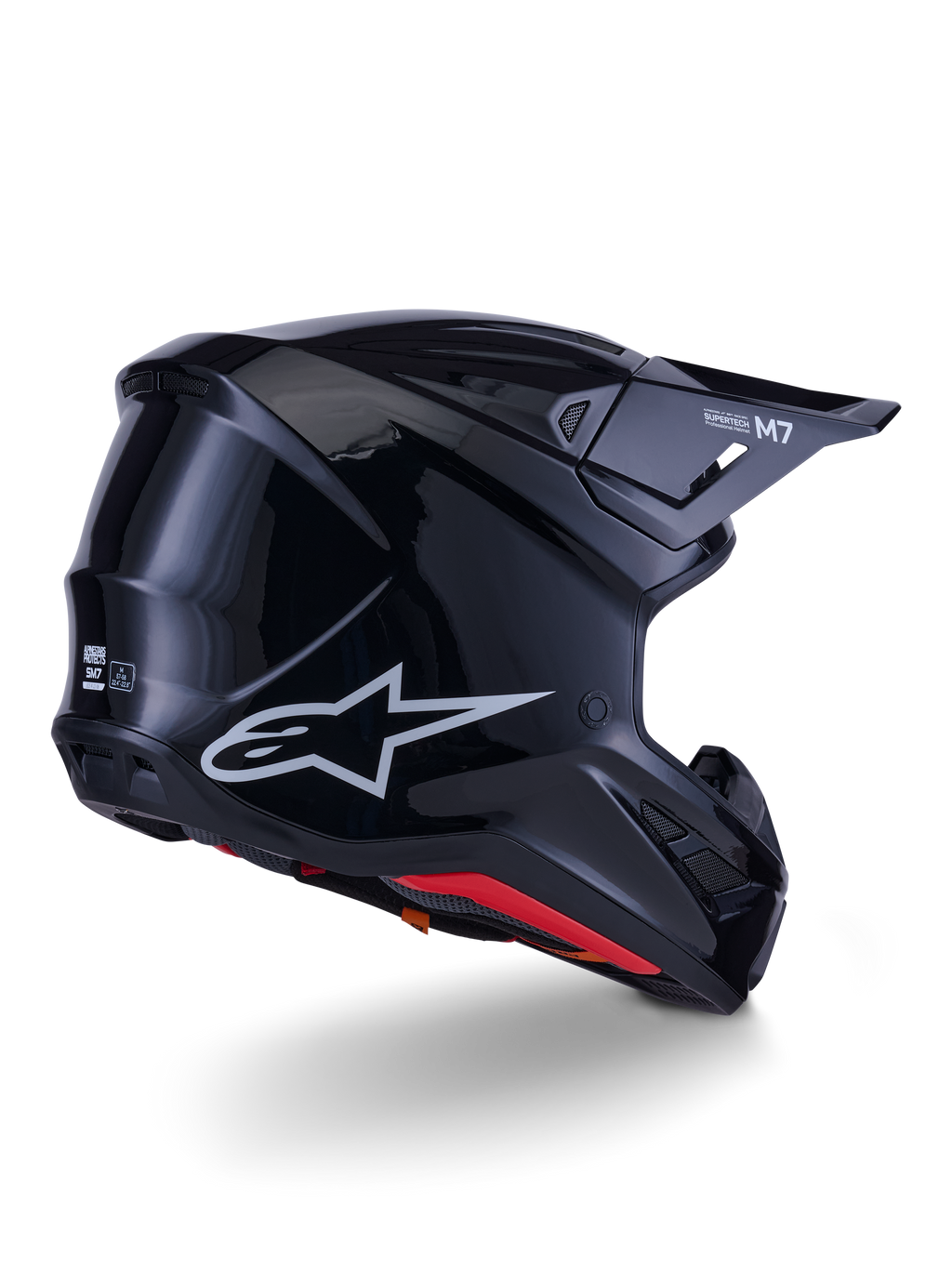 Capacete Alpinestars S-M7 Solid, capacete de motocross, preto brilhante, com uma concha aerodinâmica elegante, logótipo Astars prateado, forro interior vermelho e aberturas de ventilação integradas, concebido para proteção em corridas de todo-o-terreno