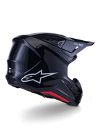 Capacete Alpinestars S-M7 Solid, capacete de motocross, preto brilhante, com uma concha aerodinâmica elegante, logótipo Astars prateado, forro interior vermelho e aberturas de ventilação integradas, concebido para proteção em corridas de todo-o-terreno
