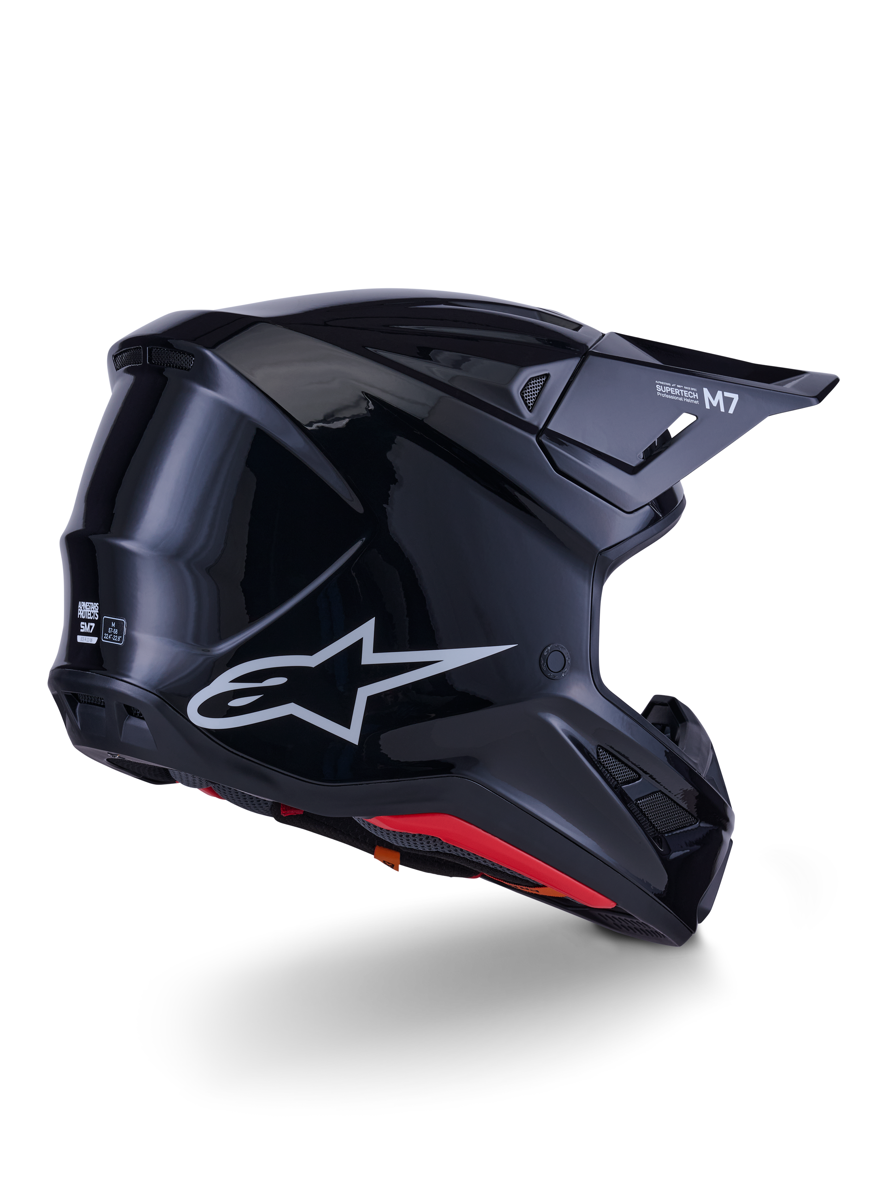 Capacete Alpinestars S-M7 Solid, capacete de motocross, preto brilhante, com uma concha aerodinâmica elegante, logótipo Astars prateado, forro interior vermelho e aberturas de ventilação integradas, concebido para proteção em corridas de todo-o-terreno