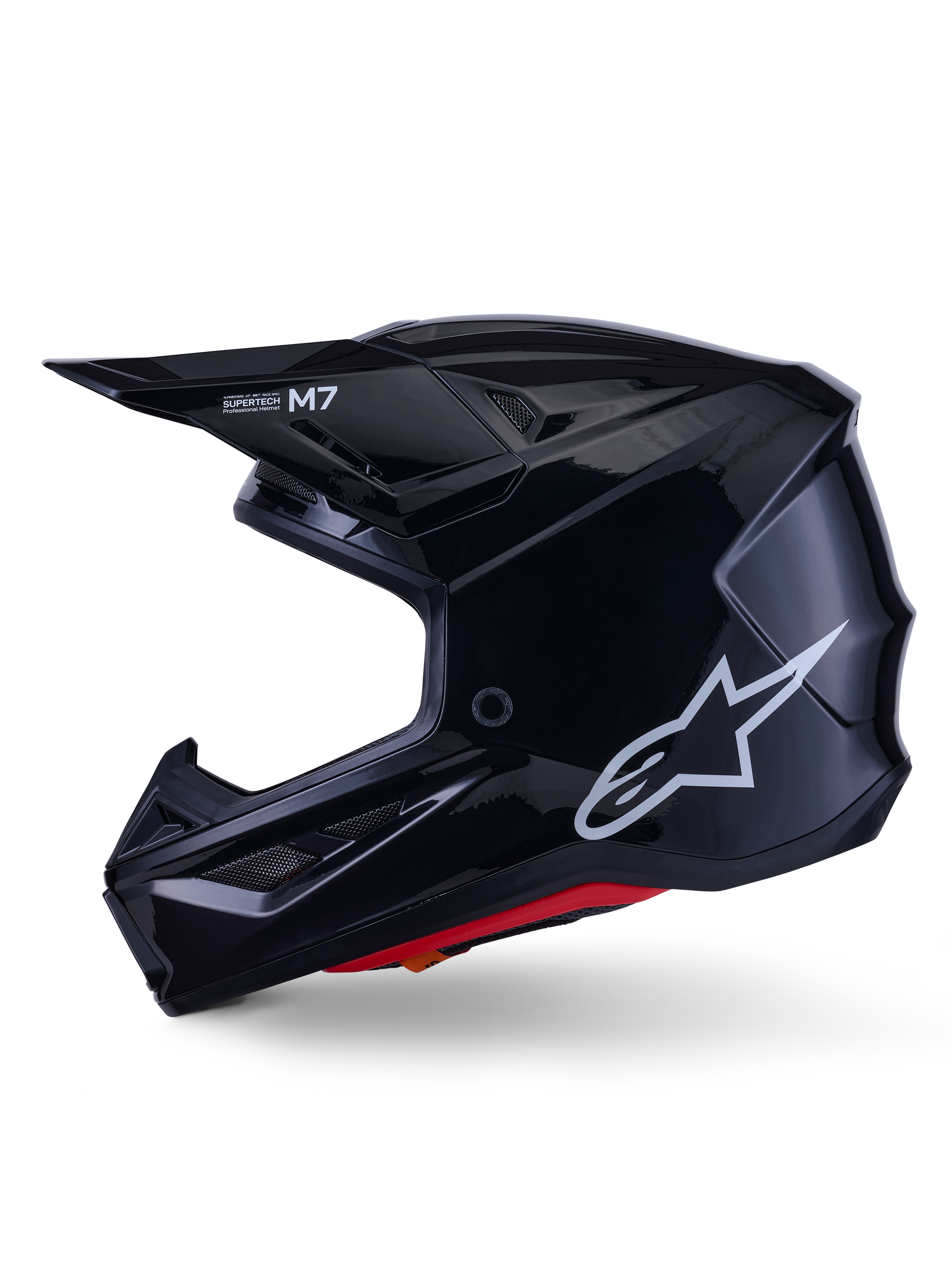 Capacete Alpinestars S-M7 Solid, capacete de motocross em preto brilhante, perfil lateral com logótipo Alpinestars branco, calota aerodinâmica com rede de ventilação e forro interior vermelho, proteção avançada para todo-o-terreno
