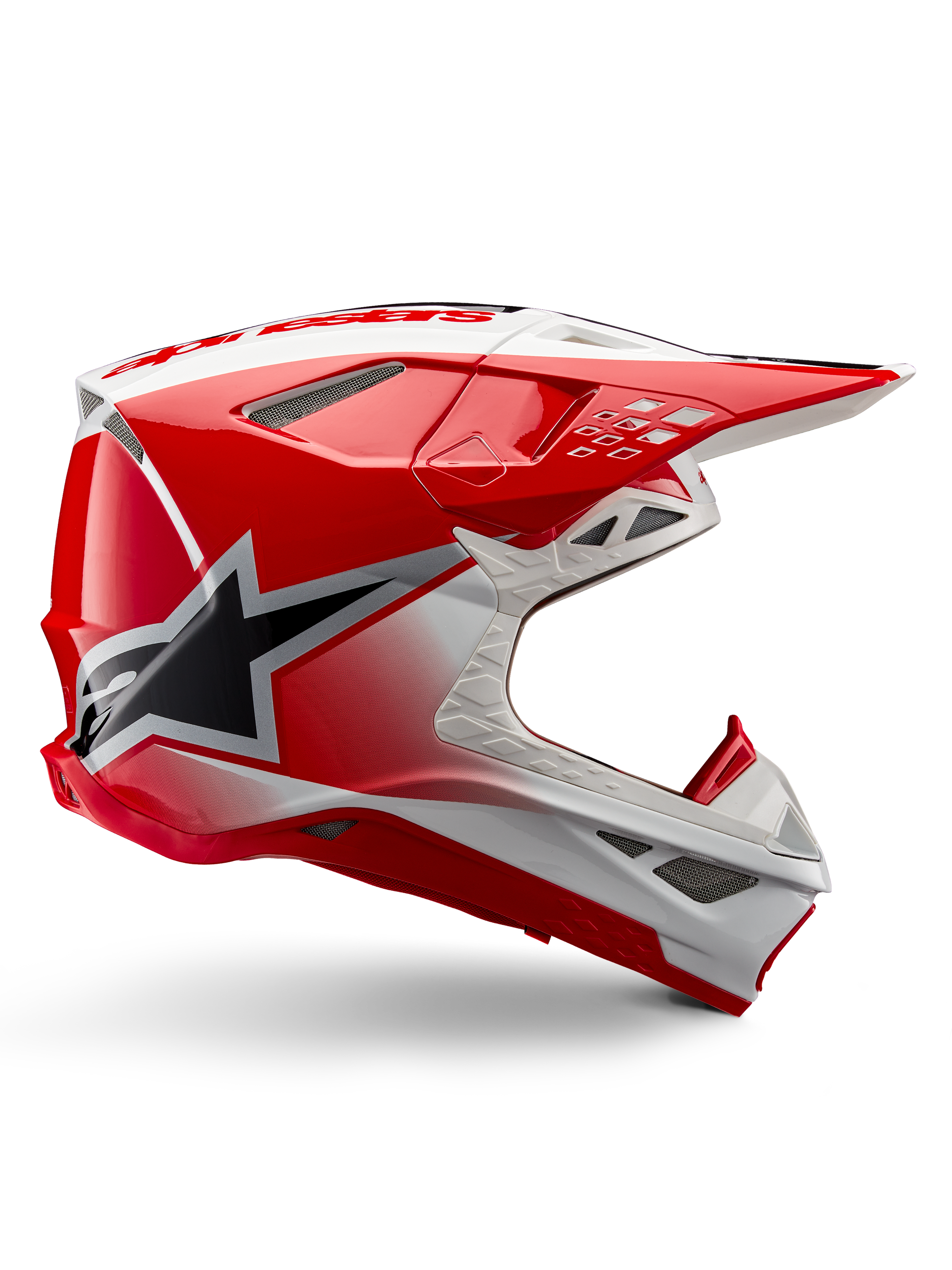 Capacete Alpinestars Supertech M10 Unite, capacete de motocross, vermelho e branco brilhante, vista lateral com padrões geométricos angulares, gráfico de estrela preta, múltiplas aberturas de ventilação em malha e design aerodinâmico para corridas todo-o-terreno