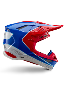 Capacete Alpinestars Supertech M10 Aeon, capacete de corrida de motocross, vermelho vivo, azul e branco, acabamento brilhante, perfil lateral aerodinâmico com múltiplas aberturas de ventilação cobertas por malha, contornos angulares e pala