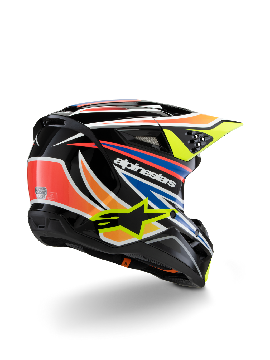 Capacete Alpinestars S-M3 Youth Wurx, capacete de motocross para jovens, preto com detalhes em laranja vibrante, vermelho, azul e amarelo fluorescente, vista traseira em três quartos mostrando a calota aerodinâmica e as aberturas de ventilação, acabamento brilhante com logótipos Alpinestars em destaque.