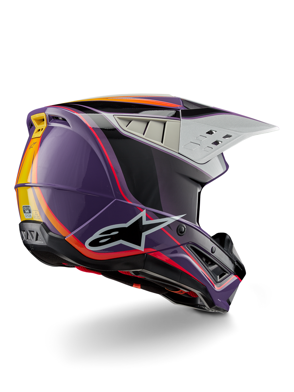 Alpinestars S-M5 Sail Helmet ECE, capacete de motocross, violeta, preto e prateado brilhante com detalhes de riscas cor-de-laranja e amarelas, grande logótipo de estrela preto, perfil aerodinâmico com saídas de ventilação traseiras, acabamento brilhante para corridas todo-o-terreno