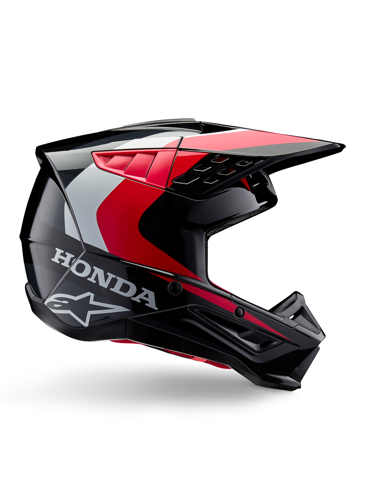 Capacete Honda S-M5, capacete de motocross, preto e vermelho brilhante com detalhes em branco e prateado, vista lateral com os logótipos Honda e Alpinestars, design aerodinâmico com viseira e múltiplas aberturas de ventilação, equipamento de proteção profissional para todo-o-terreno