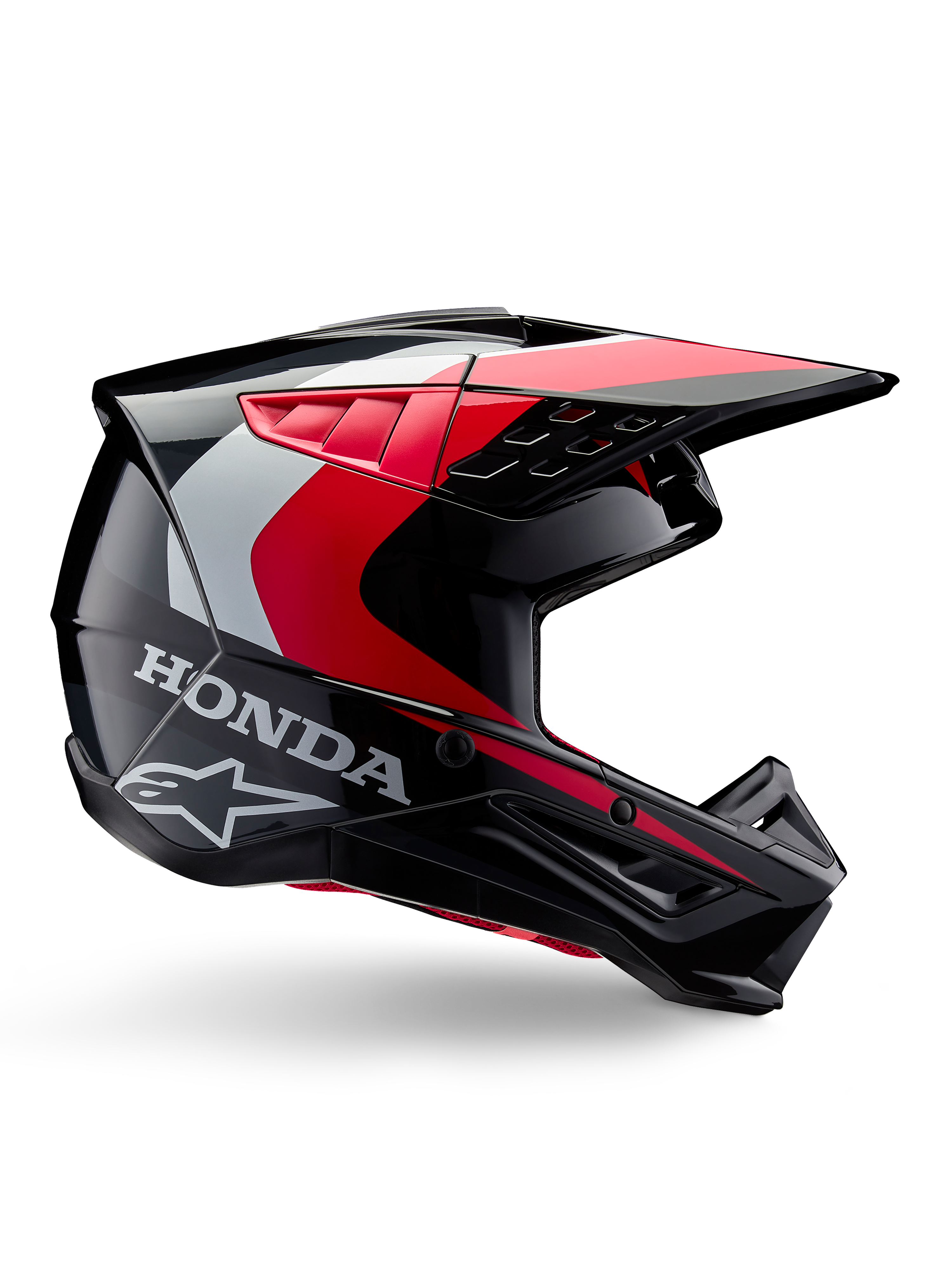 Capacete Honda S-M5, capacete de motocross, preto e vermelho brilhante com detalhes em branco e prateado, vista lateral com os logótipos Honda e Alpinestars, design aerodinâmico com viseira e múltiplas aberturas de ventilação, equipamento de proteção profissional para todo-o-terreno