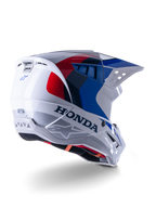 Alpinestars Honda S-M5 Helmet ECE, capacete de motocross, branco, azul e vermelho brilhante, com logótipos Honda e Alpinestars destacados, concha aerodinâmica com aberturas de ventilação integradas e viseira ajustável, equipamento de proteção para todo-o-terreno