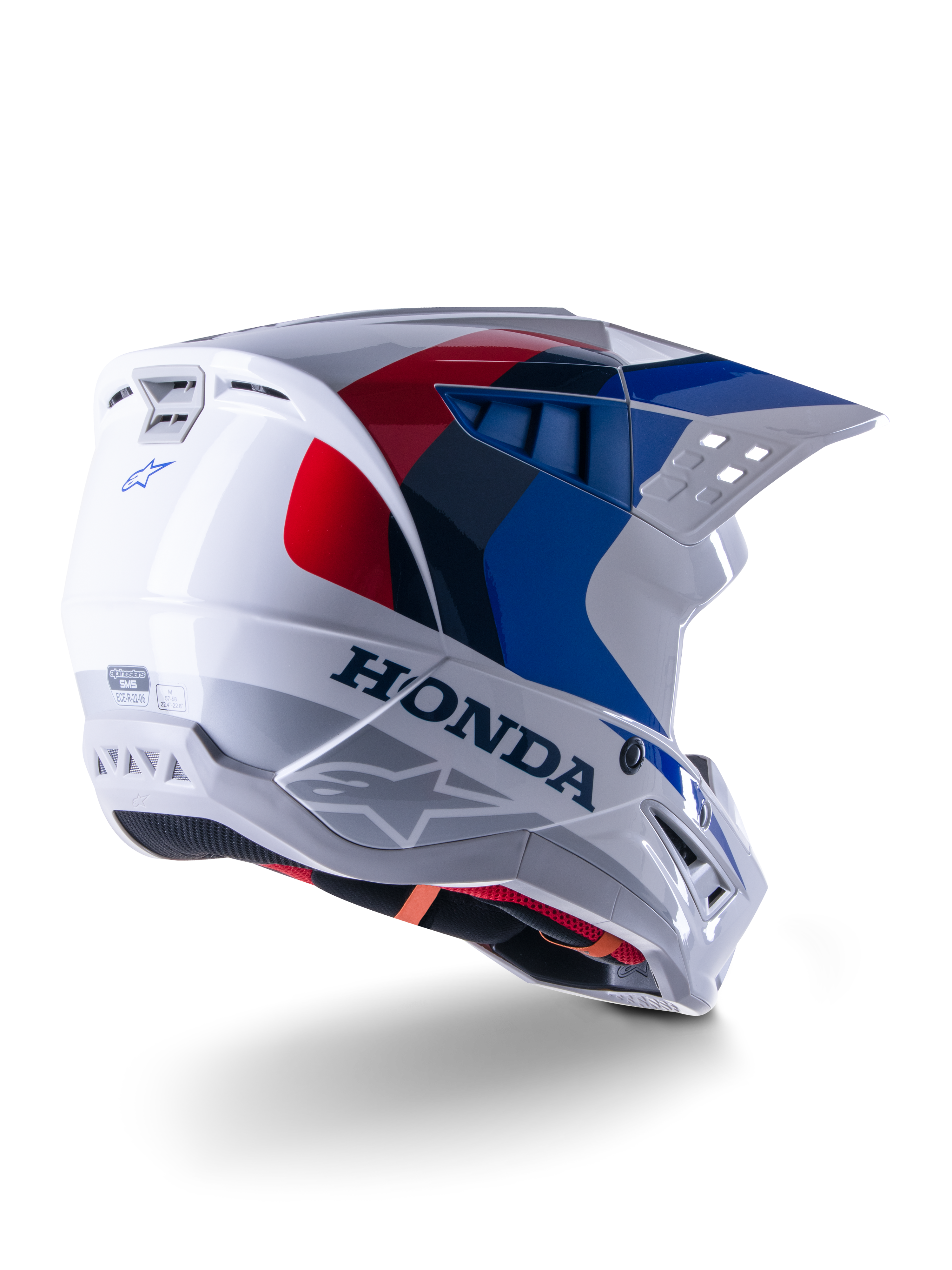 Alpinestars Honda S-M5 Helmet ECE, capacete de motocross, branco, azul e vermelho brilhante, com logótipos Honda e Alpinestars destacados, concha aerodinâmica com aberturas de ventilação integradas e viseira ajustável, equipamento de proteção para todo-o-terreno