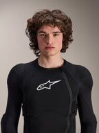 Modelo masculino a usar o Casaco de Proteção Alpinestars A-Impact Plasma - Manga Comprida, preto com logótipo Astars branco, com fecho de correr frontal deslocado e acolchoamento integrado, equipamento de proteção profissional para BTT