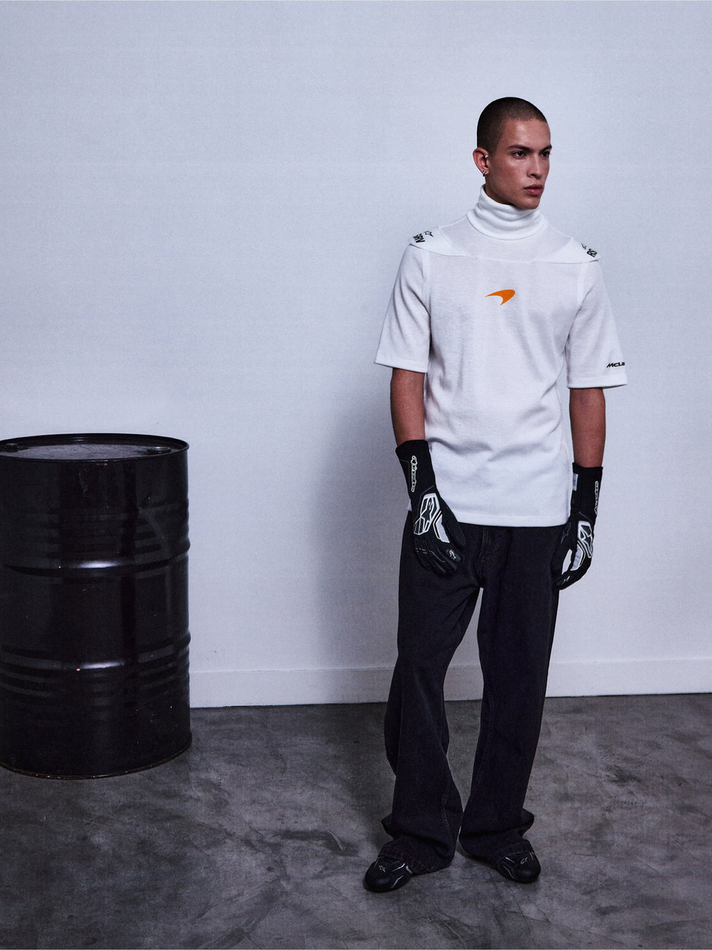 Alpinestars RSRV Pyro SS Tee, t-shirt branca de gola alta e manga curta com logótipo laranja, estilo streetwear premium, pessoa vestida com luvas pretas e calças pretas