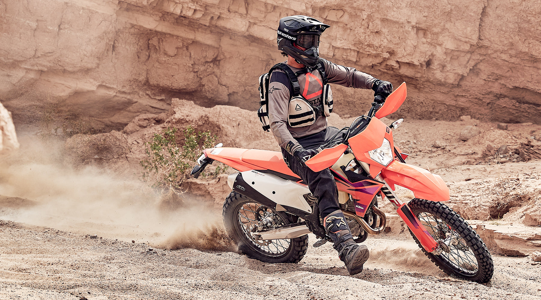 Alpinestars Tech 7 Enduro AND Drystar Boots, black off-road boots on an enduro rider with an orange motorcycle.