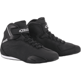 These black high-top Sektor Shoes by Alpinestars EU showcase a modern design, featuring a black textured pattern on the sides, a logo on the ankle straps, and white accents on the back and sole. They boast a speed lacing system and durable microfiber construction for a sleek, sporty appearance.