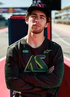 Alpinestars Ayess Csf Tee, t-shirt de manga comprida, preta, com grafismos AS em degradê verde e amarelo no peito e nas mangas, streetwear casual inspirado no desporto motorizado usada num circuito