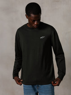 Alpinestars Essentials Ageless LS Tee, t-shirt de manga comprida, Off Black, com um pequeno logótipo branco no peito, vestida por um modelo com calças de ganga azuis, estilo casual lifestyle streetwear