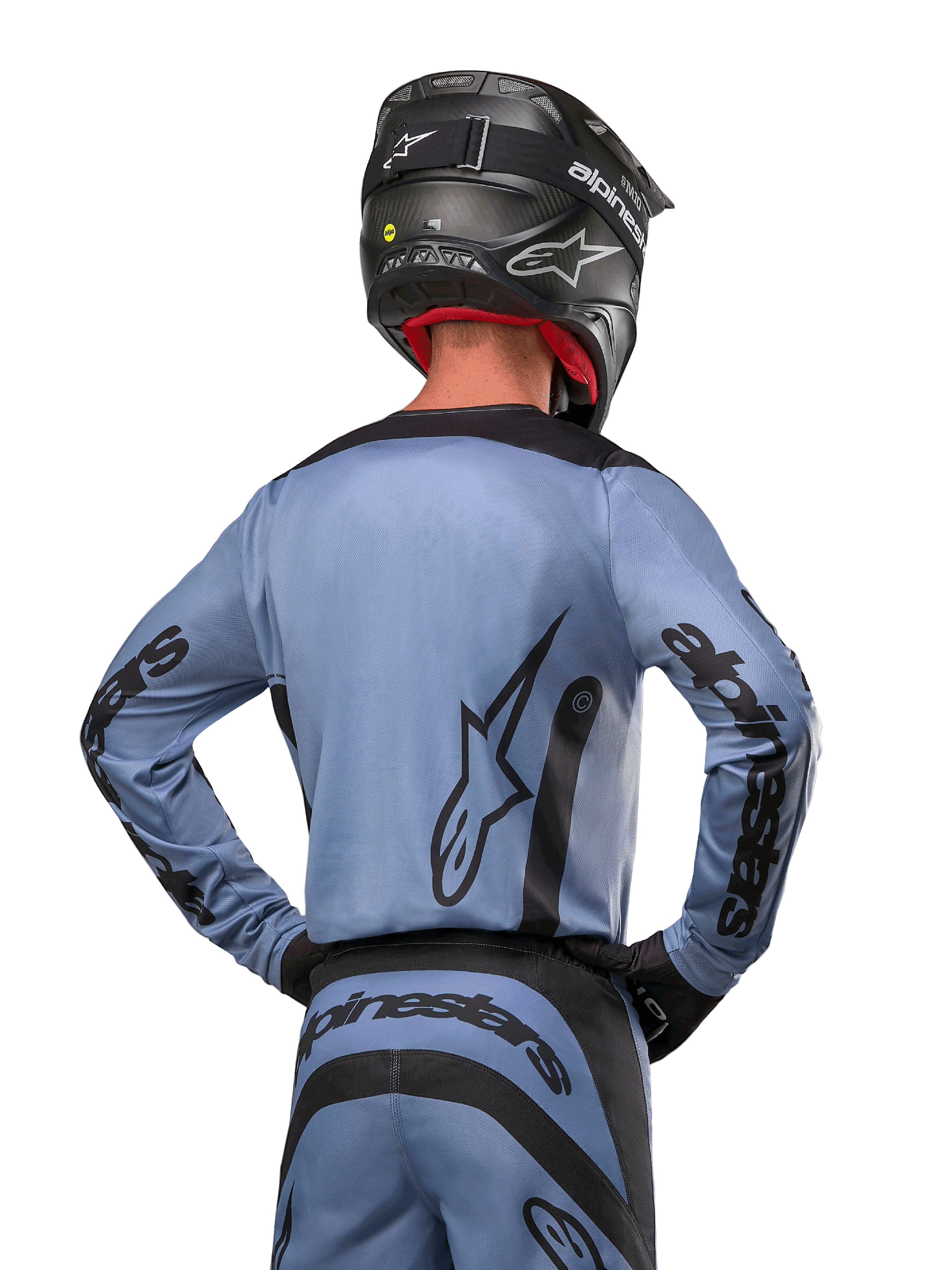 Alpinestars 2024 Fluid Lurv Jersey, camisola de motocross, azul claro e preto, vista traseira do piloto mostrando o grande logótipo de estrela e a marca nas mangas, usada com um capacete preto e calças de todo-o-terreno a condizer, vestuário de corrida profissional