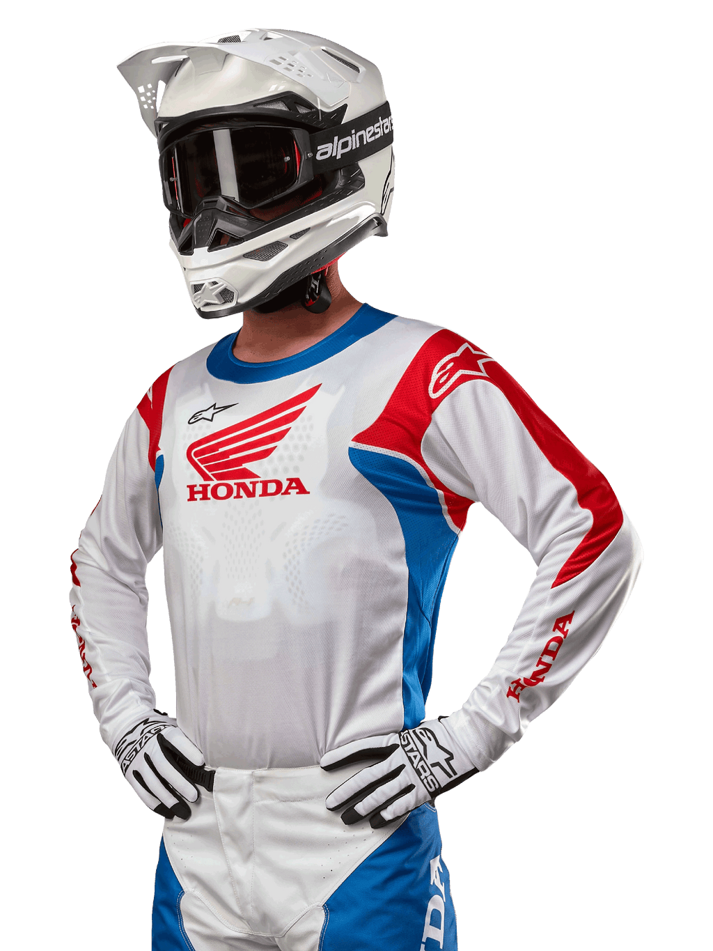 Motocross rider wearing the Honda Racer Iconic Jersey in White, Bright Blue, and Bright Red, featuring a large Honda wing logo on the chest, paired with a white Alpinestars helmet and matching white and black gloves, coordinated gear for off-road performance