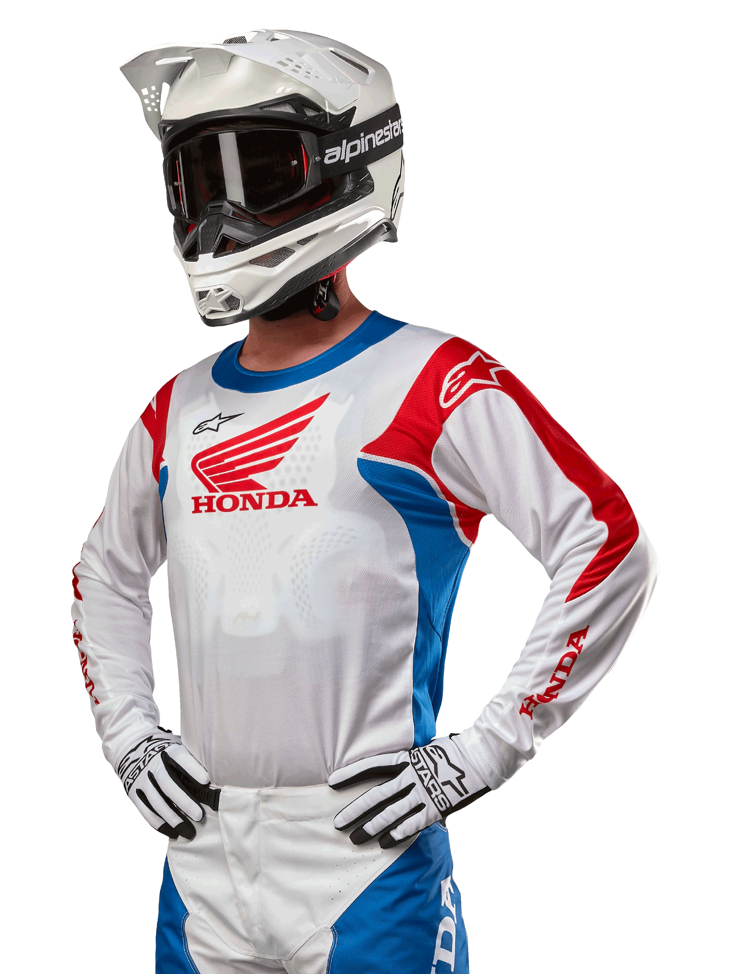 Motocross rider wearing the Honda Racer Iconic Jersey in White, Bright Blue, and Bright Red, featuring a large Honda wing logo on the chest, paired with a white Alpinestars helmet and matching white and black gloves, coordinated gear for off-road performance