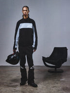 Alpinestars RSRV Track Jacket, casaco desportivo preto e cinzento com logótipo de estrela, pessoa com capacete a condizer, estilo urbano minimalista, coleção streetwear premium