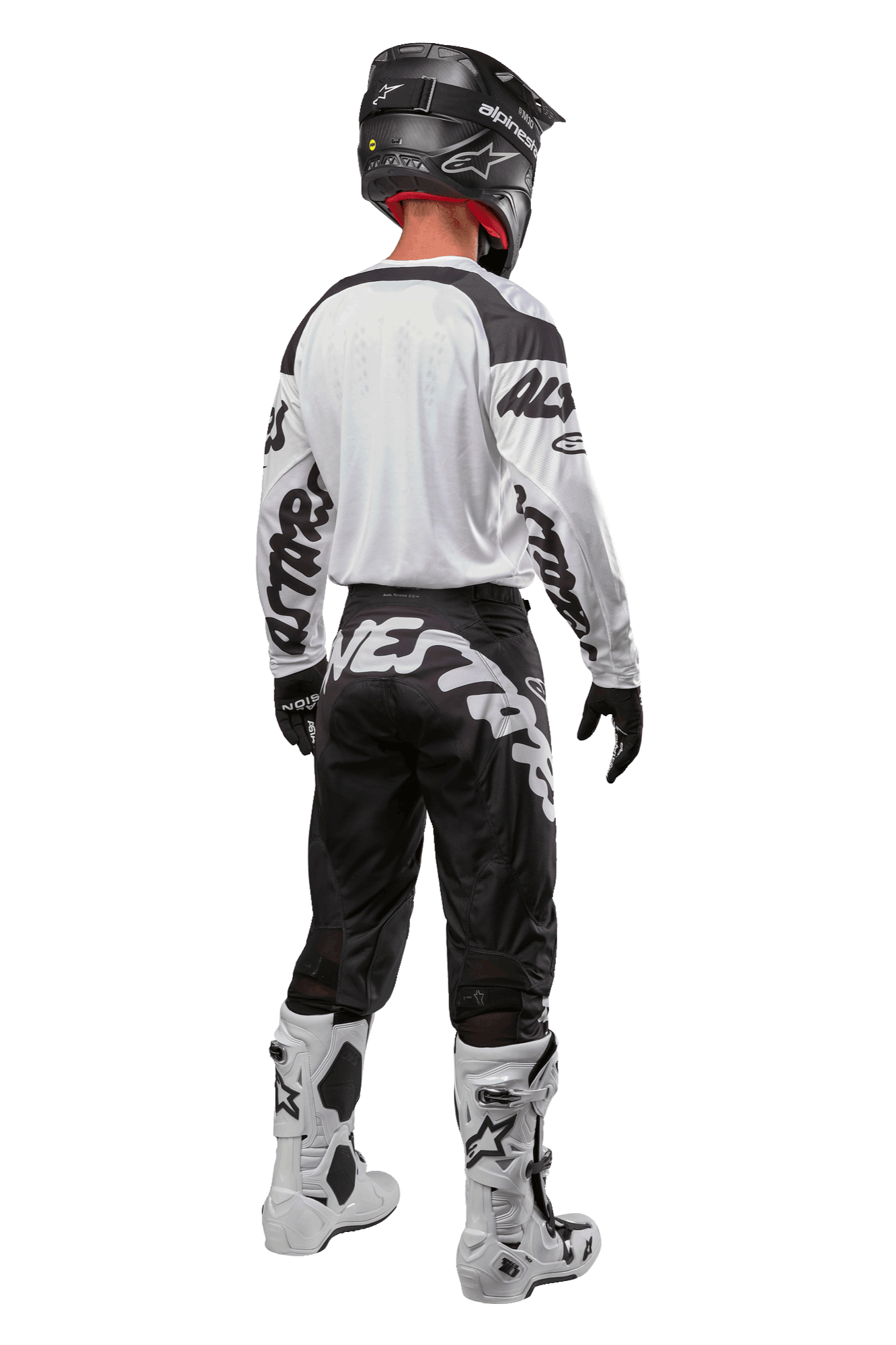 Equipamento completo de motocross Alpinestars visto de costas, incluindo calças 2024 Racer Hana pretas e brancas com logótipo, camisola branca, capacete preto e botas brancas, vestuário técnico para pilotagem off-road
