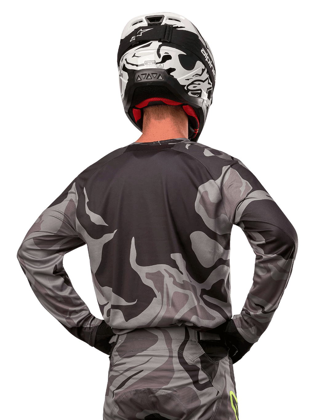 Alpinestars 2024 Racer Tactical Jersey, camisola de motocross, Cast Gray Camo Magnet, vista traseira com padrão de camuflagem cinzento e preto, usada com calças a condizer e um capacete preto e branco, equipamento profissional de corrida para todo-o-terreno