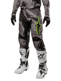 Alpinestars 2024 Racer Tactical Pants, calças de motocross, camuflado cinzento e preto, logótipo de estrela verde lima, usadas com botas brancas e pretas e luvas pretas, equipamento de todo-o-terreno