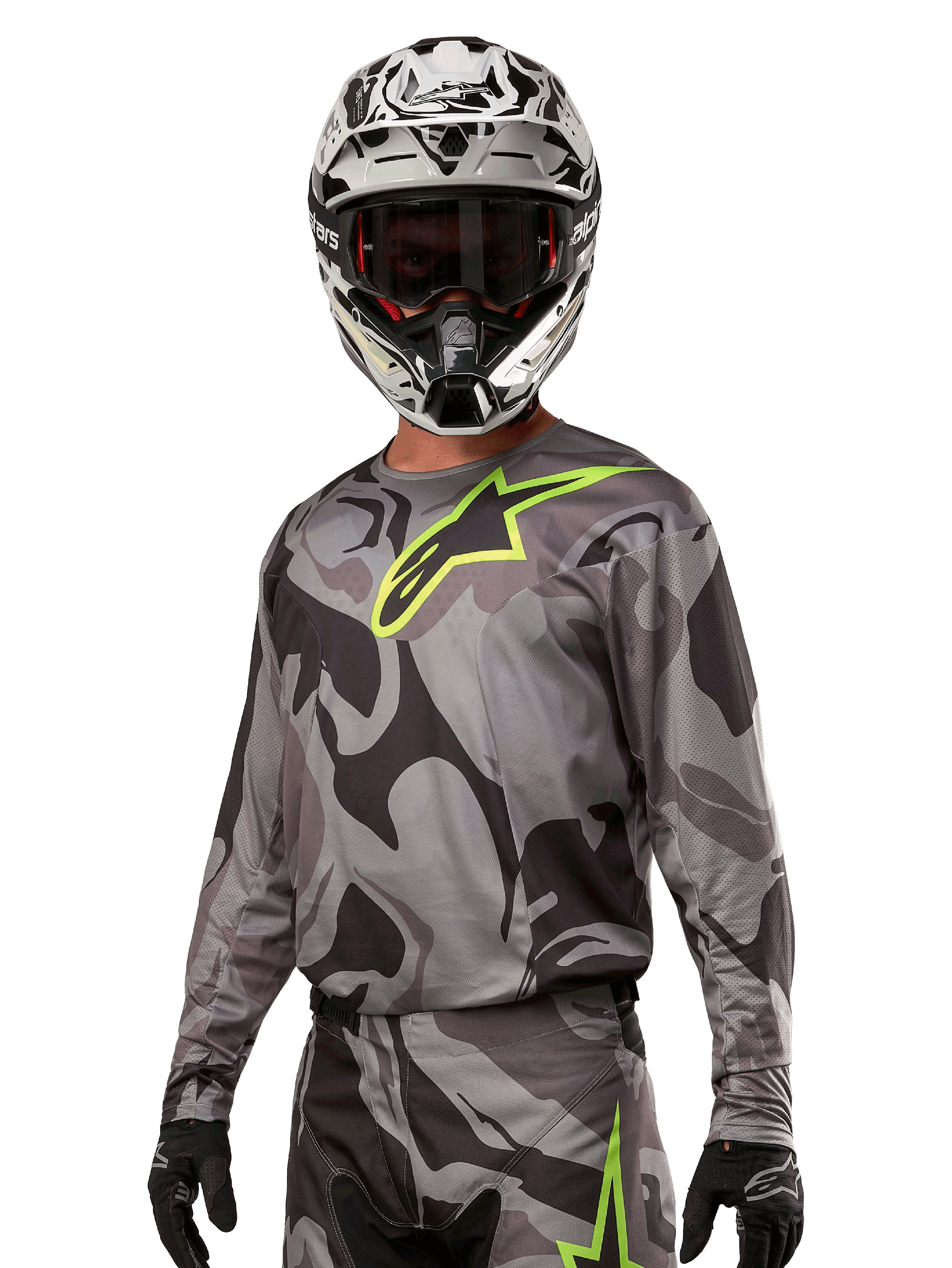 Camisola Alpinestars Racer Tactical 2024, camisola de motocross, camuflagem em tons de cinzento com logótipo verde néon, usada com capacete preto e branco e luvas pretas, tecido técnico que absorve a humidade para corridas de todo-o-terreno