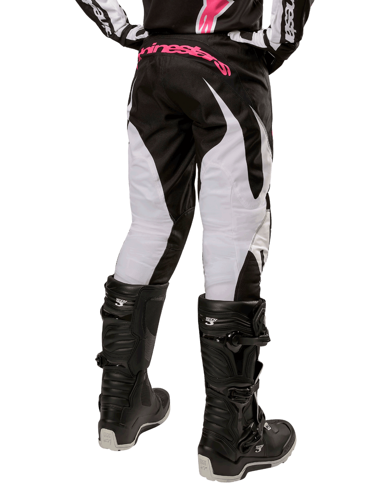 Alpinestars Stella Fluid Pants 2024 para Mulher, calças de motocross, pretas e brancas, vista traseira com painéis brancos nas pernas e logótipo cor-de-rosa no cós, usadas com botas Tech 3 pretas, equipamento durável para todo-o-terreno