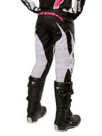 Alpinestars Stella Fluid Pants 2024 para Mulher, calças de motocross, pretas e brancas, vista traseira com painéis brancos nas pernas e logótipo cor-de-rosa no cós, usadas com botas Tech 3 pretas, equipamento durável para todo-o-terreno