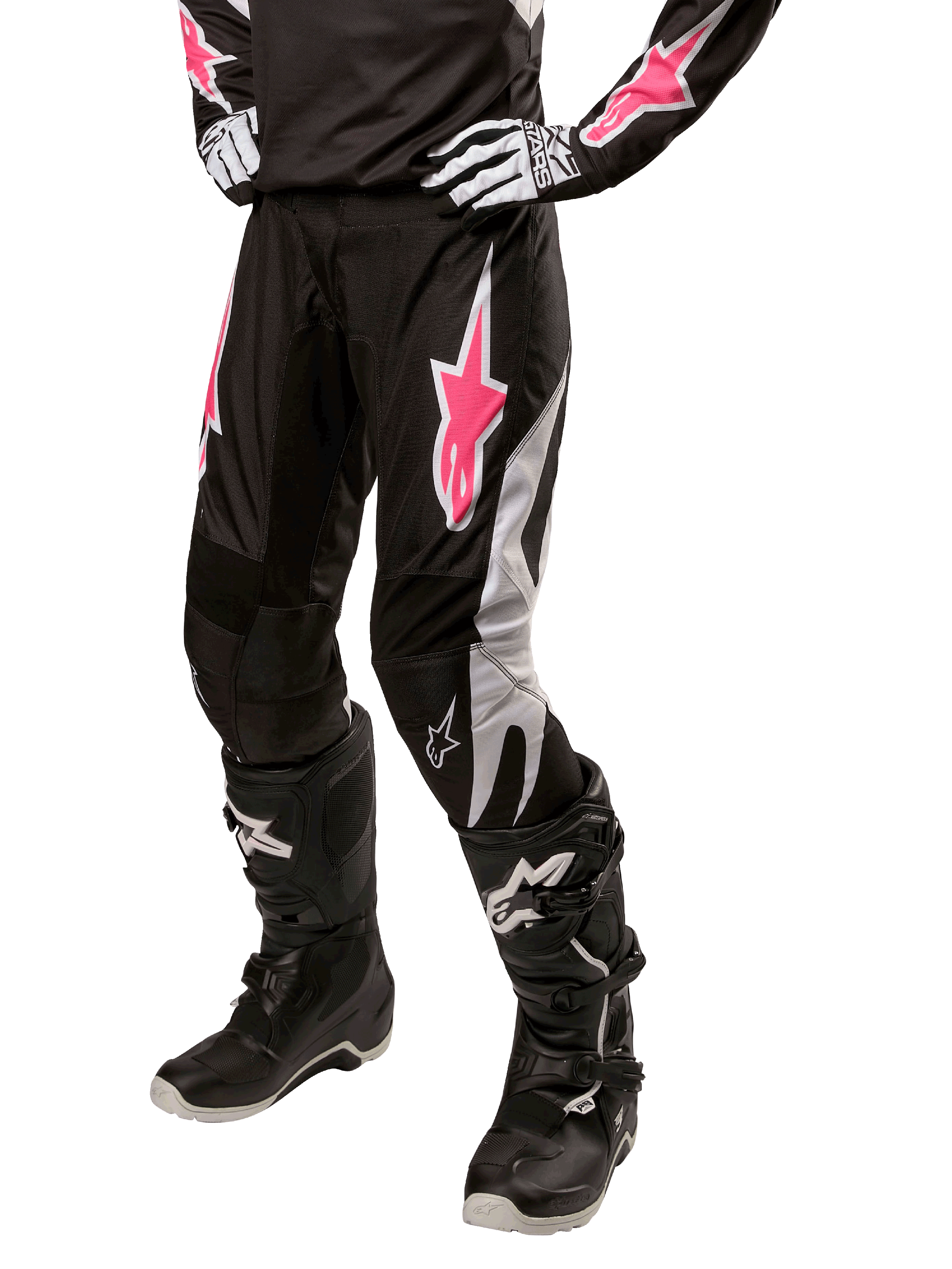 Alpinestars Stella Fluid Pant 2024, calças de motocross para mulher, pretas e brancas com detalhes cor-de-rosa, usadas com equipamento de proteção a condizer, incluindo botas e luvas, tecido resistente e flexível para condução fora de estrada
