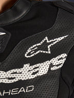 Pormenor do Fato de Cabedal Stella GP-R7 de 2 Peças da Alpinestars em preto, com painéis de pele perfurada, um logótipo Alpinestars branco no peito e secções de tecido elástico respirável.
