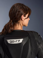 Fato de Cabedal Alpinestars Stella GP-R7 de 2 Peças, preto, vista aproximada das costas com o logótipo GP-R7 na corcova aerodinâmica, painéis de pele em sanfona nos ombros, construção de qualidade de corrida premium para mulher.