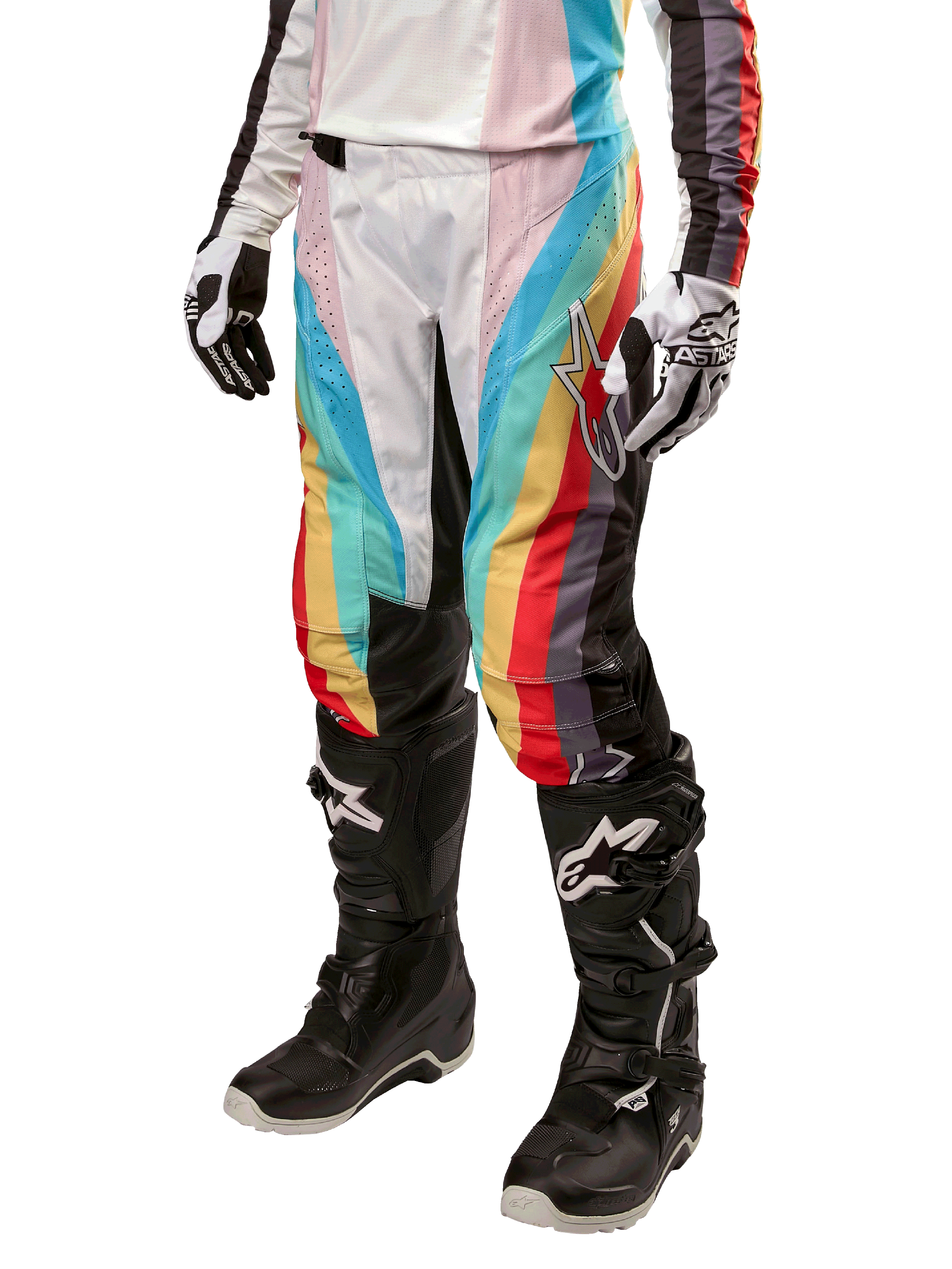 Calças Alpinestars Stella Techstar 2024 para Mulher, calças de motocross, pretas multicor com riscas diagonais vermelhas, amarelas e azuis, usadas com botas de condução pretas e luvas brancas, com painéis de proteção pretos nos joelhos e logótipo de destaque para corridas de todo-o-terreno.