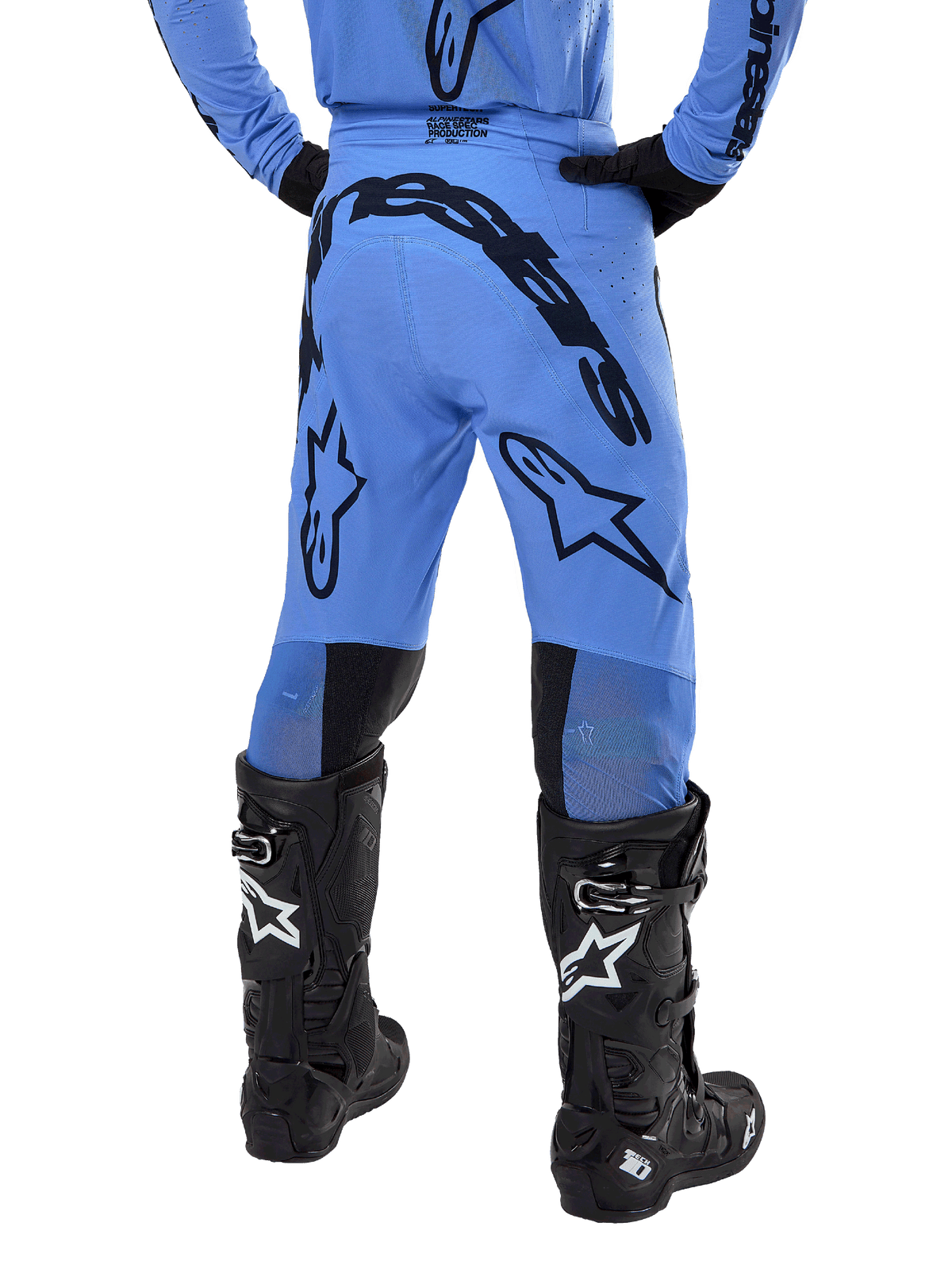 Alpinestars 2024 Supertech Dade Pants, calças de motocross, azul claro, vista traseira com grandes logótipos pretos no assento e nas pernas, combinadas com botas Alpinestars Tech 10 pretas, corte atlético para performance profissional em todo-o-terreno