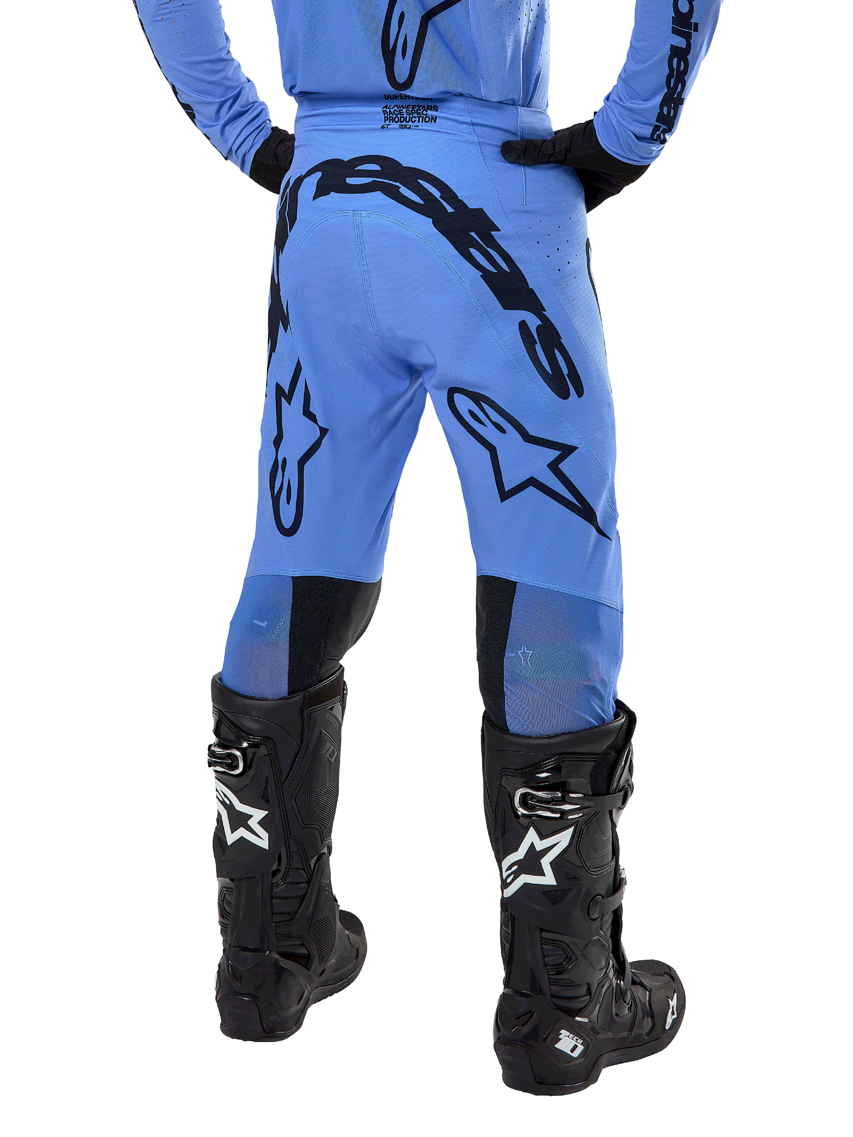 Alpinestars 2024 Supertech Dade Pants, calças de motocross, azul claro, vista traseira com grandes logótipos pretos no assento e nas pernas, combinadas com botas Alpinestars Tech 10 pretas, corte atlético para performance profissional em todo-o-terreno