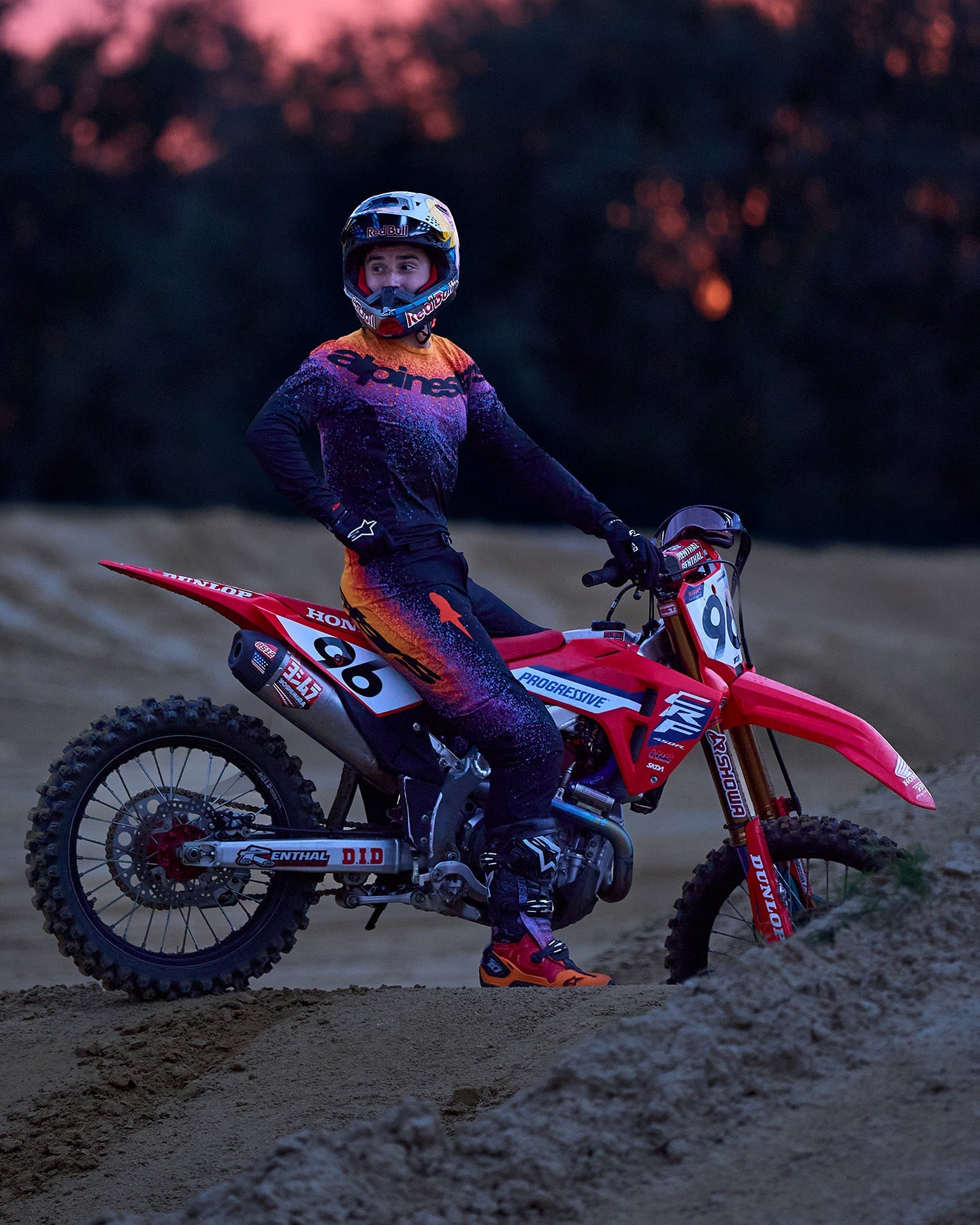 Alpinestars Supertech Black Hole Goggles and Tech 10 Boots, black and orange motocross gear on a red racing bike.