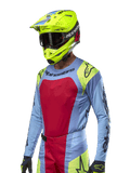 2024 Techstar Ocuri Jersey, Motocross Racing Jersey, Light Blue with Red and Fluo Yellow accents, worn with matching neon yellow helmet and black goggles, featuring black Alpinestars logos on chest and shoulders, athletic race-inspired design for off-road performance