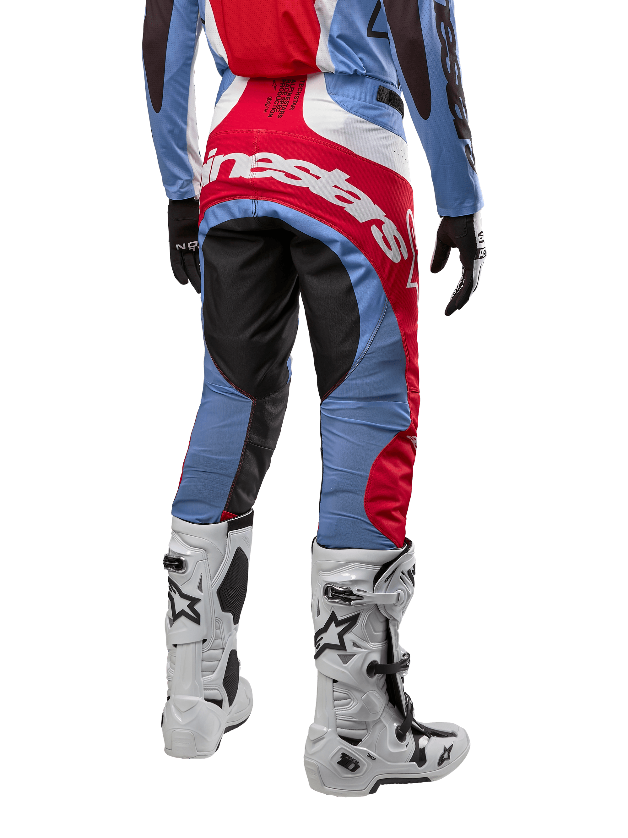 Alpinestars 2024 Techstar Ocuri Pants, calças de motocross em azul claro, vermelho Mars e branco, vista traseira destacando o grande logótipo Alpinestars vermelho no assento, combinadas com botas de corrida brancas e camisola a condizer