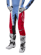 Alpinestars 2024 Techstar Ocuri Pants, calças de motocross, azul claro, vermelho Mars e branco, usadas com camisola azul claro e botas brancas, com o logótipo de estrela na coxa e joelhos reforçados, equipamento completo de corrida todo-o-terreno