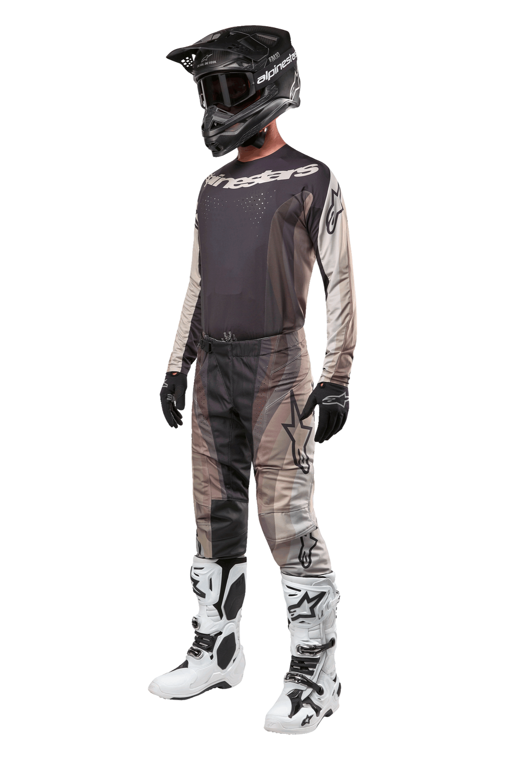 Alpinestars 2024 Techstar Pneuma Pants, calças de motocross, Dark Sand Iron Dust Gray, usadas como parte de um conjunto completo com camisola a condizer, capacete preto, luvas pretas e botas brancas, com padrões de camuflagem do deserto e logótipos de grandes dimensões