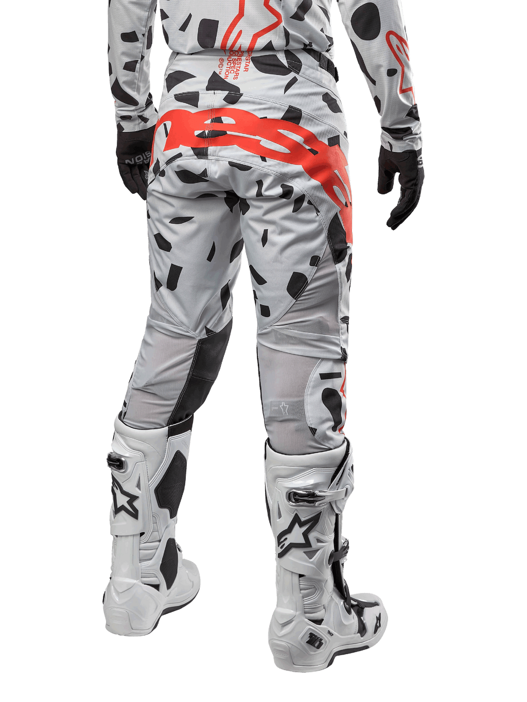 Alpinestars 2024 Techstar Rantera Pants, calças de motocross, camuflado cinzento Haze com padrões pretos e um logótipo Alpinestars grande em vermelho no assento, vista traseira com botas brancas e equipamento de corrida a condizer