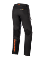 Calças Alpinestars AMT-10R Drystar® XF, pretas com detalhes em cor de laranja, vista traseira mostrando o logótipo vertical Alpinestars em cor de laranja na perna esquerda, painéis texturizados nos joelhos e logótipos Kevlar e Matryx, calças técnicas de motociclismo adventure touring