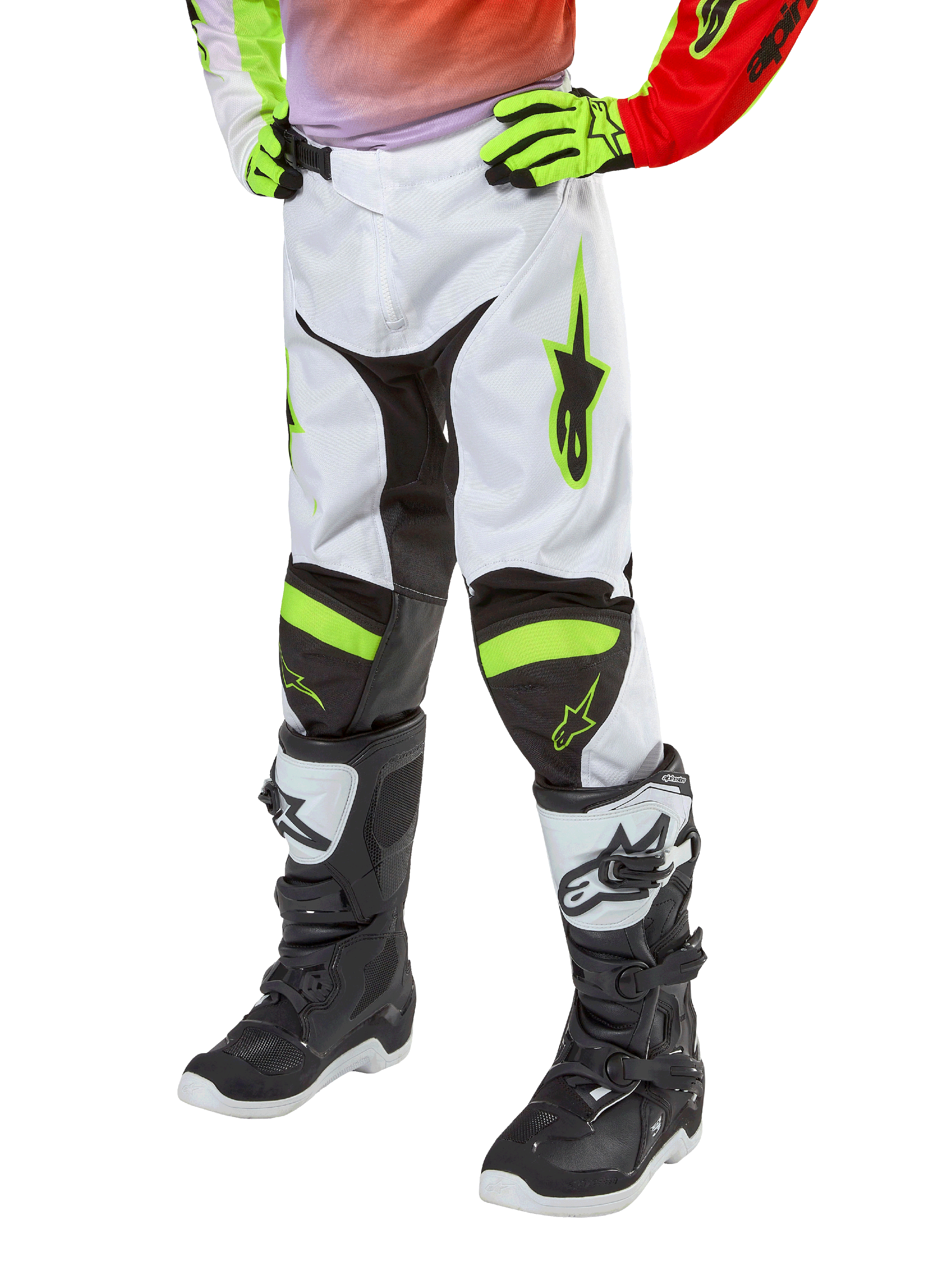 Alpinestars Youth 2024 Racer Lucent Pants, calças de motocross, brancas, vermelho néon e amarelo fluo, vista da parte inferior do corpo com painéis elásticos pretos e detalhes néon, usadas com botas de corrida pretas e brancas e luvas amarelo néon, equipamento técnico de todo-o-terreno para jovens