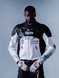 Alpinestars RSRV Threadline Leather Jacket, casaco de motociclista premium, preto e branco, com patches RSRV, ombros acolchoados, fecho de correr completo, estilo urbano de luxo, pessoa a usar luvas brancas com detalhes vermelhos